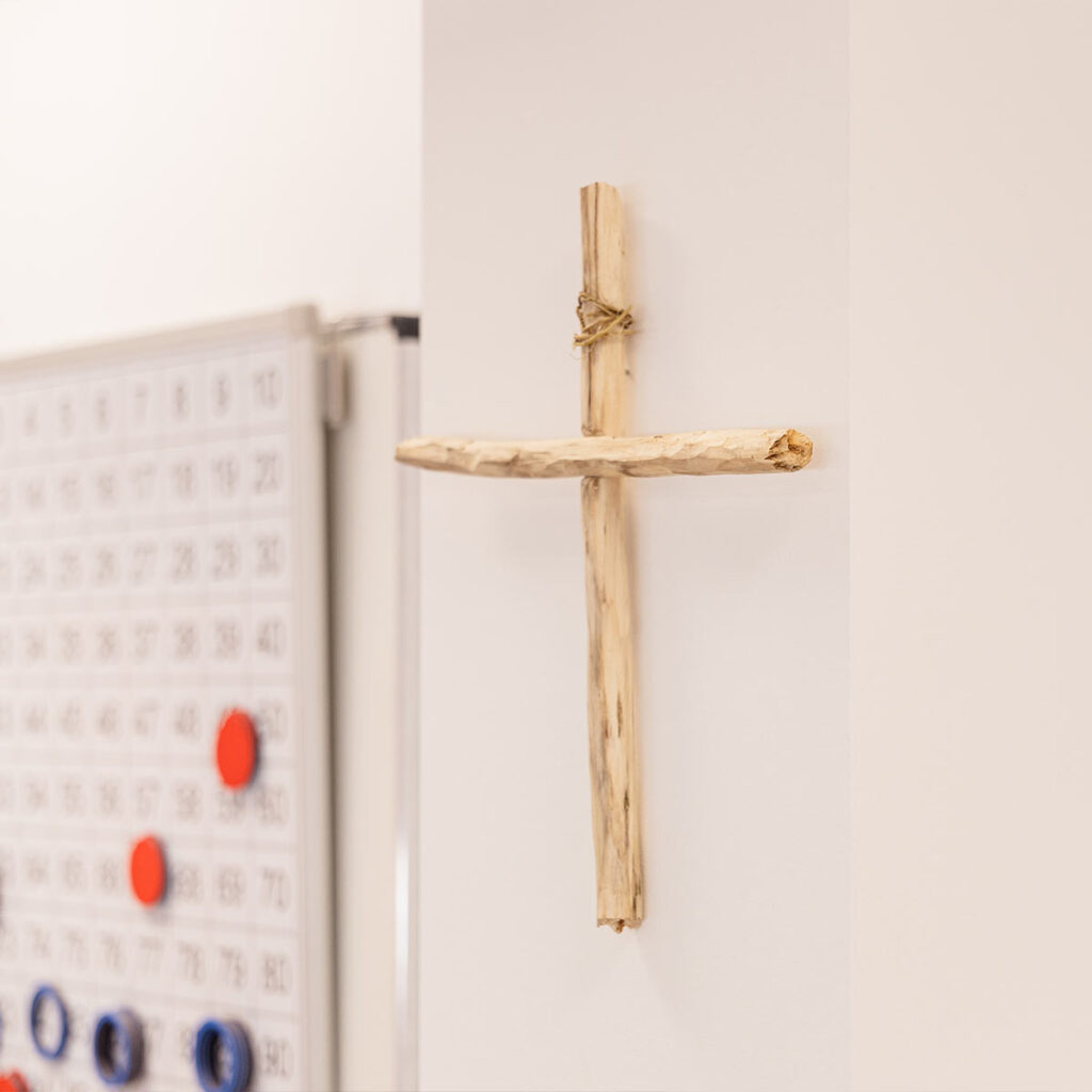 Holzkreuz im Klassenraum der katholischen Grundschule Celle als Zeichen gelebter christlicher Werte.