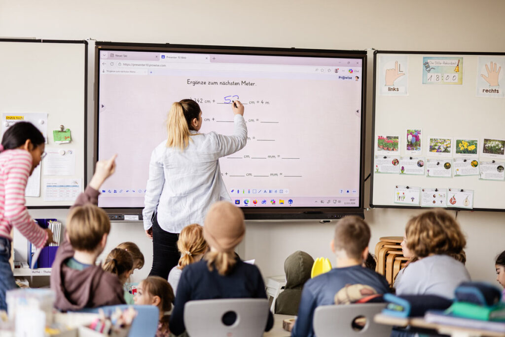 Kinder lernen gemeinsam mit digitalen Medien im modernen Bildungskonzept der katholischen Grundschule Celle.