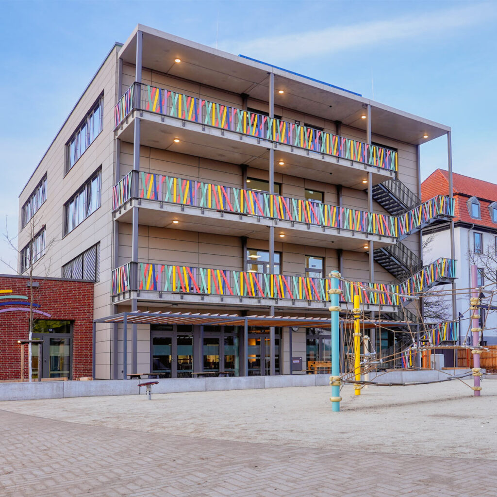 Modernes Schulgebäude der katholischen Grundschule Celle mit großzügigem Schulhof und Lernbereichen.